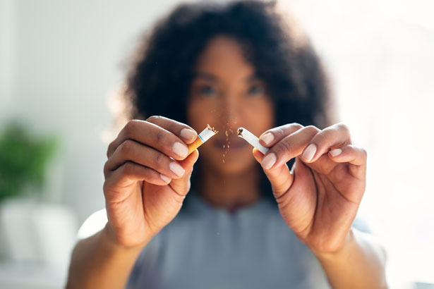 Close-up of woman breaking a cigarette down to pieces